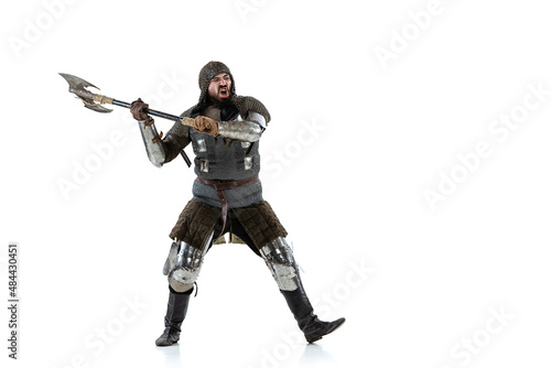 Full-length portrait of brutal serious man, medieval knight swinging ax, ready to figth isolated over white studio background © master1305