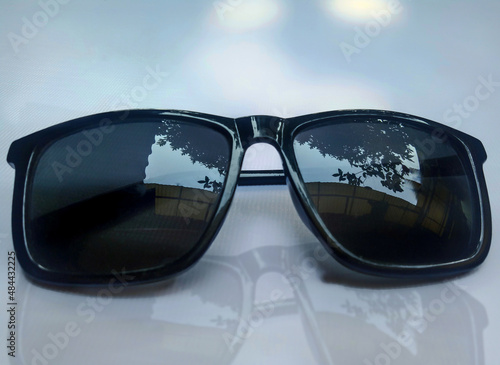 a pair of sunglasses on a soft white blue background and shadow effect