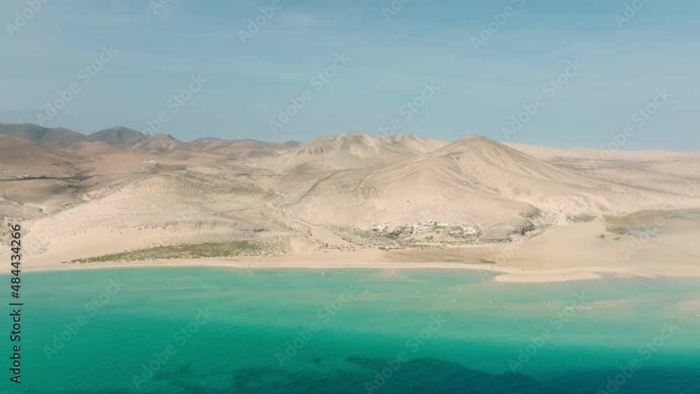 Beautiful sand dunes meet the Atlantic Ocean. Top view of Fuerteventura sand dunes. Aerial view of Canary Islands. Atlantic ocean meets sand dunes on the Canary islands. Beautiful sand dunes meet the Atlantic Ocean. Top view of Fuerteventura sand dunes. Aerial view of Canary Islands. Atlantic ocean meets sand dunes on the Canary islands.