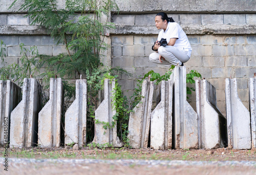 Asian Professional cameraman sits and thinks about how to create a creativity photo in the construction area background and environment. photo