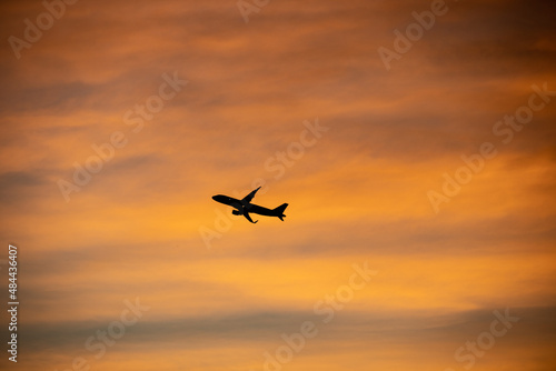 Airliner flying over colorful sunset