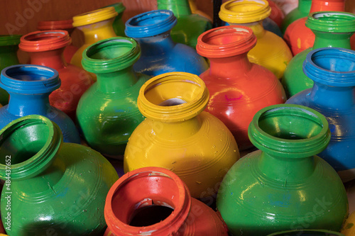 Auspicious pots are painted with colors and displayed at pandal, during Durga Puja festival at night. Shot under colored light at Howrah, West Bengal, India. Biggest festival of Hinduism,. photo