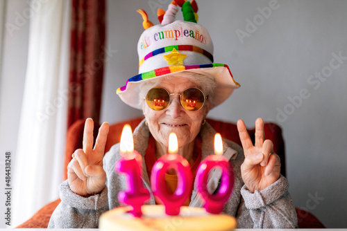 Cheerful elderly woman celebrating birthday with cake photo