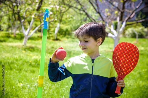 Happy boy is playing tetherball swing ball game in summer campin photo