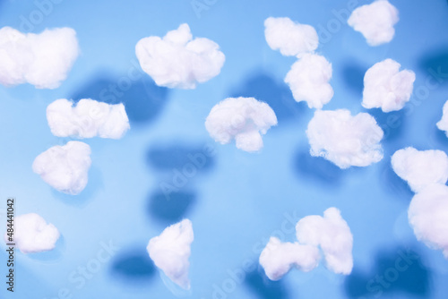 Photography White cotton fake clouds on a pastel blue background.