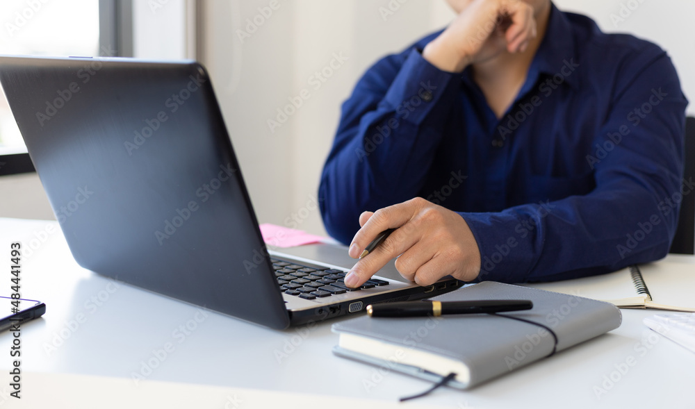 Businessman contemplating while working on laptop in office. Businessman contemplating while working on laptop in office.