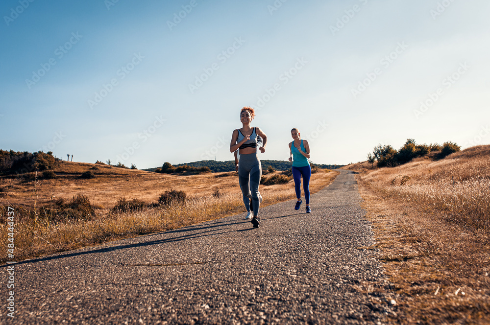 Group of sporty female friends running outdoors. Group of sporty female friends running outdoors.