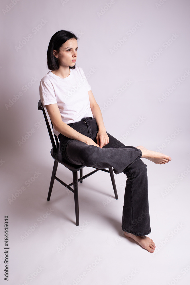 woman in white t-shirt sits on a chair woman in white t-shirt sits on a chair