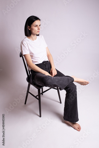 woman in white t-shirt sits on a chair