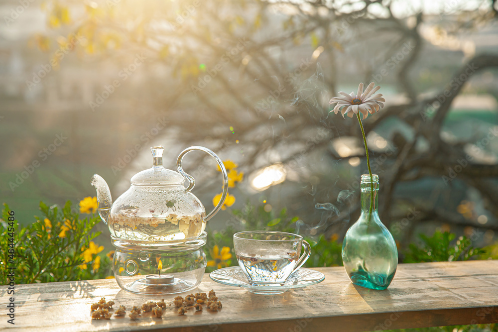 Chrysanthemum tea with hot steam and sweet potato jam on wooden table, in the backyard background in the afternoon sunlight Chrysanthemum tea with hot steam and sweet potato jam on wooden table, in the backyard background in the afternoon sunlight