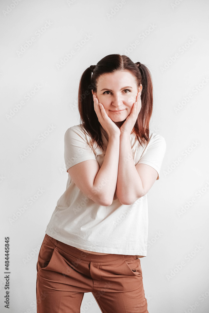 Woman with pigtails and a funny face wearing a T-shirt on a white background. Copy, empty space Woman with pigtails and a funny face wearing a T-shirt on a white background. Copy, empty space