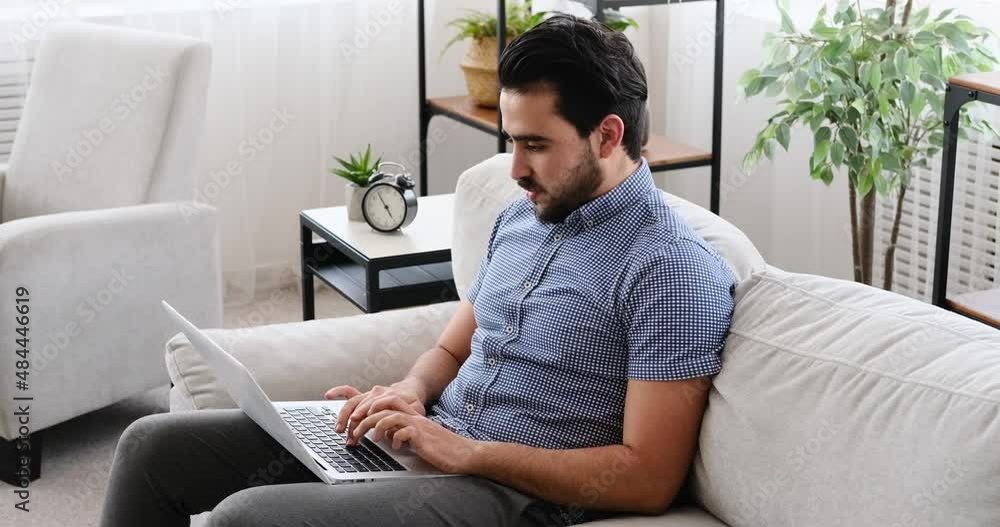 Businessman using laptop while sitting on sofa at home Businessman using laptop while sitting on sofa at home