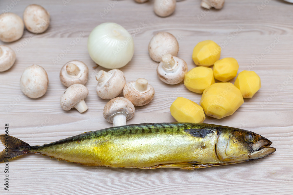 Raw fresh champignons and mackerel fish on a white wooden table. Raw fresh champignons and mackerel fish on a white wooden table.