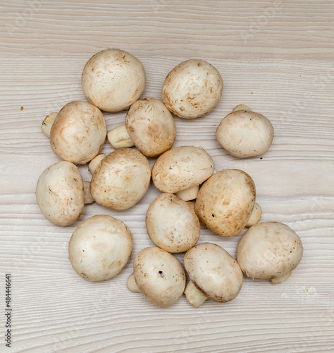 Raw fresh champignons on a white wooden table.