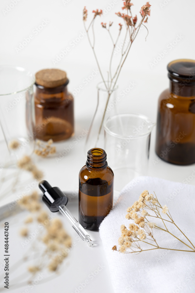 Brown serum dropper bottle with aroma flower and laboratory flask Brown serum dropper bottle with aroma flower and laboratory flask