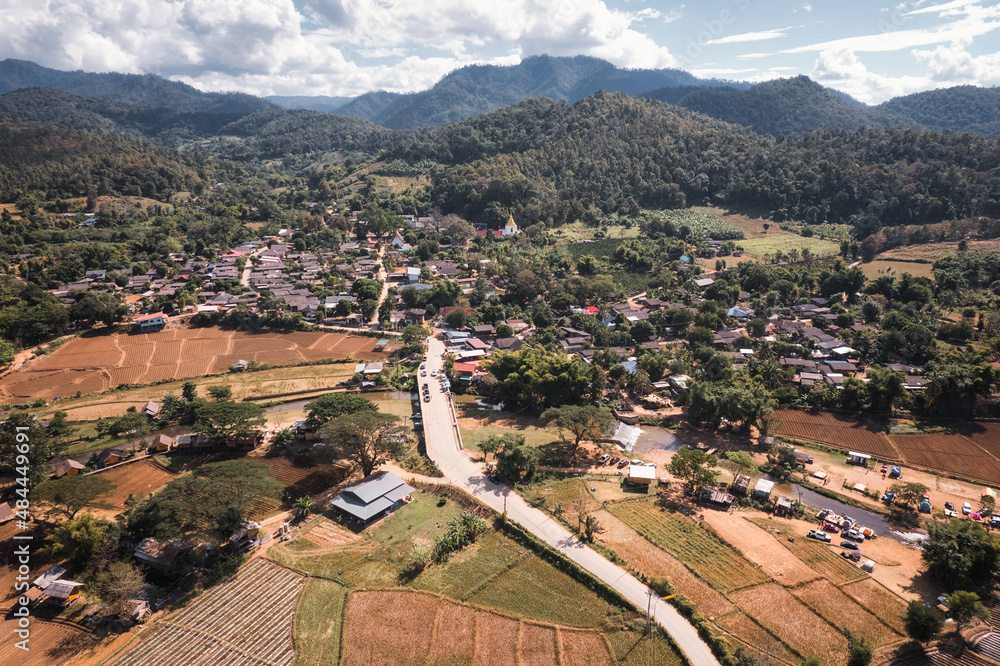 Tranquil local village with river flowing through among the valley and rice plantation on dry season in countryside
