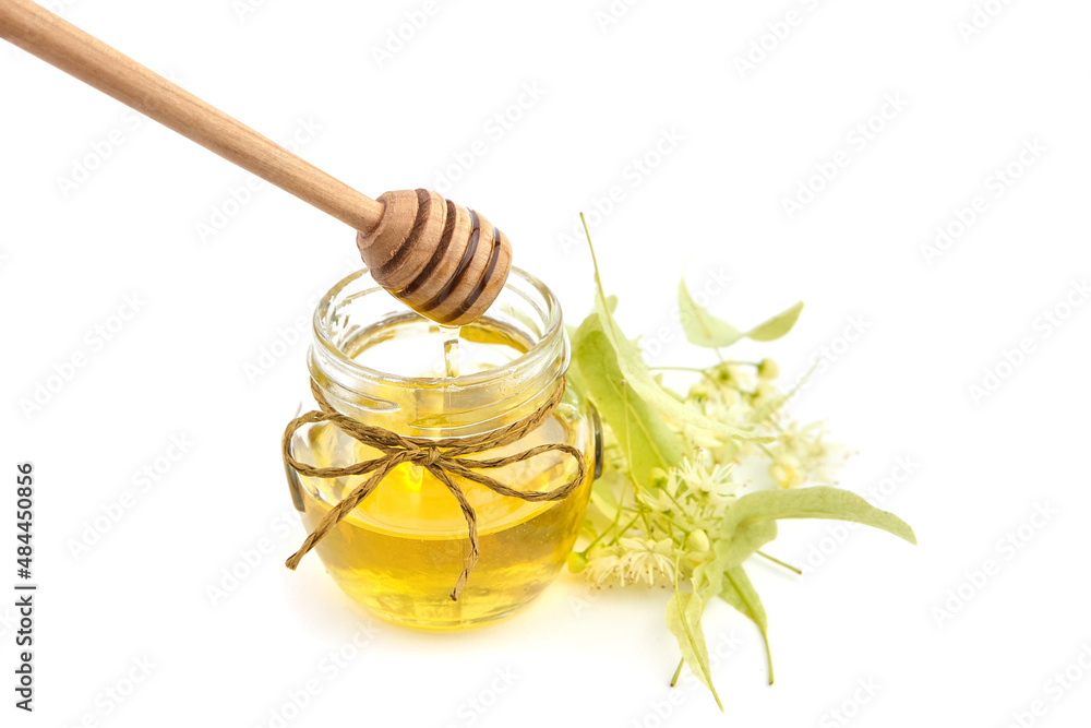 Honey jar with linden blossom and wooden dipper isolated on white Honey jar with linden blossom and wooden dipper isolated on white
