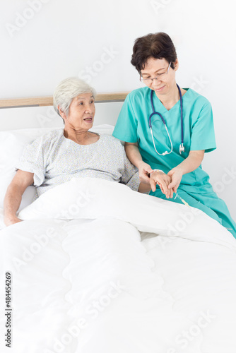 doctor talk with old asian patient about disease symptom , elderly health care,  she holding hand of patient, rehabilitation