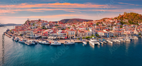 Fantastic sunset in Poros town. Picturesque summer seascape of Myrtoan Sea with a lots of yachts. Attractive evening scene of Peloponnese peninsula, Greece. Traveling concept background..
