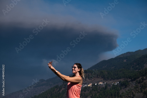 blonde-haired woman taking a selfie with storm clouds