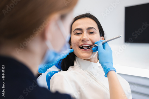 Pretty brunette woman at the dentist appointment. Female patient treats her teeth in a dental clinic