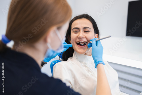 Happy woman at the preventive examination at the dentist. Female patient in dental clinic