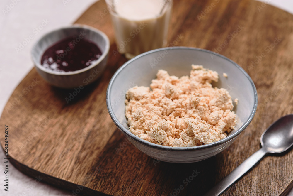 Homemade melted cheese curd served with baked milk and jam on wooden cutboard. Healthy breakfast. Haze effect. Selective focus Homemade melted cheese curd served with baked milk and jam on wooden cutboard. Healthy breakfast. Haze effect. Selective focus