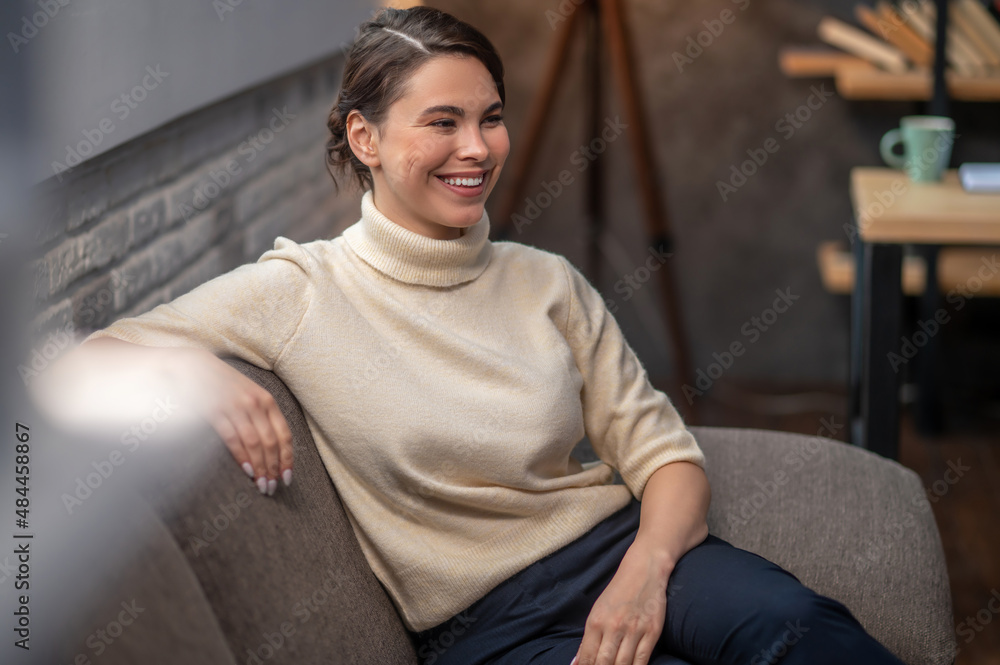 Fototapeta premium Happy lady seated on the sofa indoors