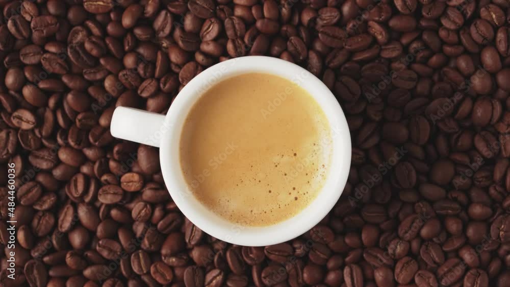 Cup of fresh aromatic coffee with crema, rotate with coffee beans, top view. Cup of fresh aromatic coffee with crema, rotate with coffee beans, top view.
