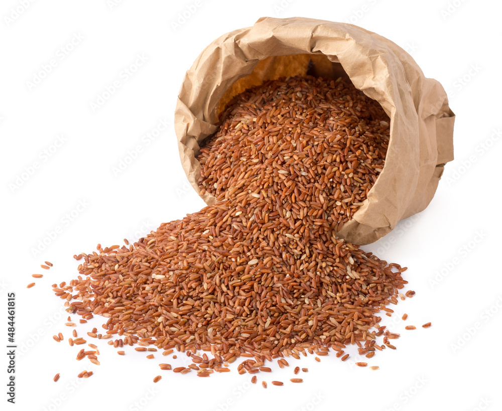 scattered whole grain dark brown rice from a paper bag, also called ...