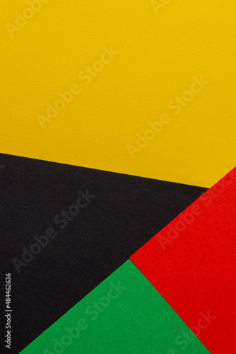 Abstract colored paper geometry composition background in black, red, yellow, green colors with copy space for text