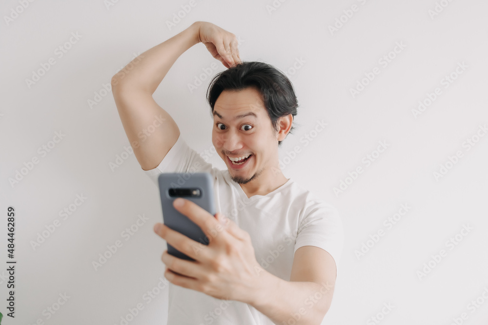Asian man send love sign to girlfriend online in the smartphone application. Asian man send love sign to girlfriend online in the smartphone application.