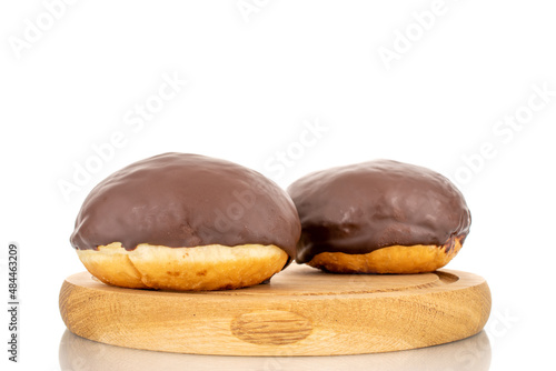 Two flavored chocolate donuts on a wooden tray, macro, isolated on a white background.