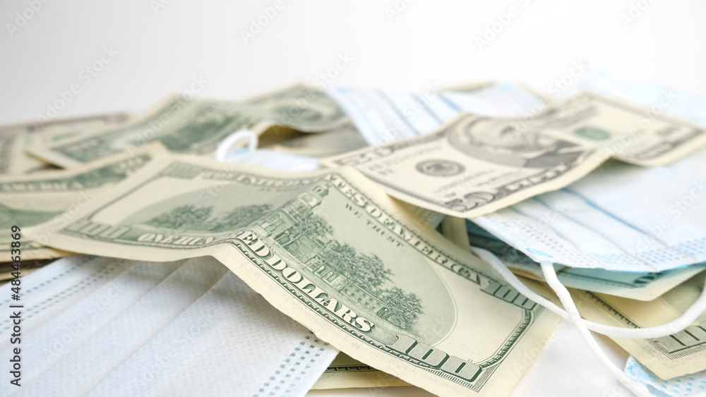 Background from money. Scattered dollars and medical mask Background from money. Scattered dollars and medical mask
