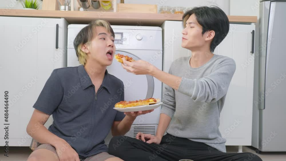 Asian handsome man gay family sitting on floor, eating pizza together. Asian handsome man gay family sitting on floor, eating pizza together.