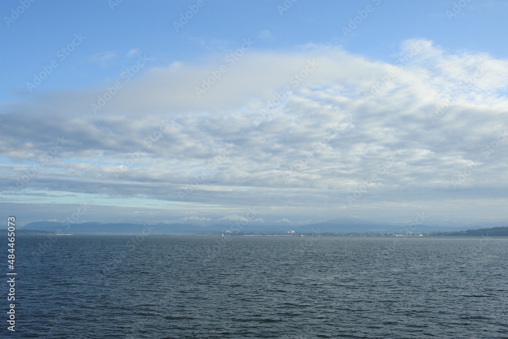 The picturesque scenery of the Puget Sound, with Everett Washington, and the snow covered North Cascades Mountains in the distance. 