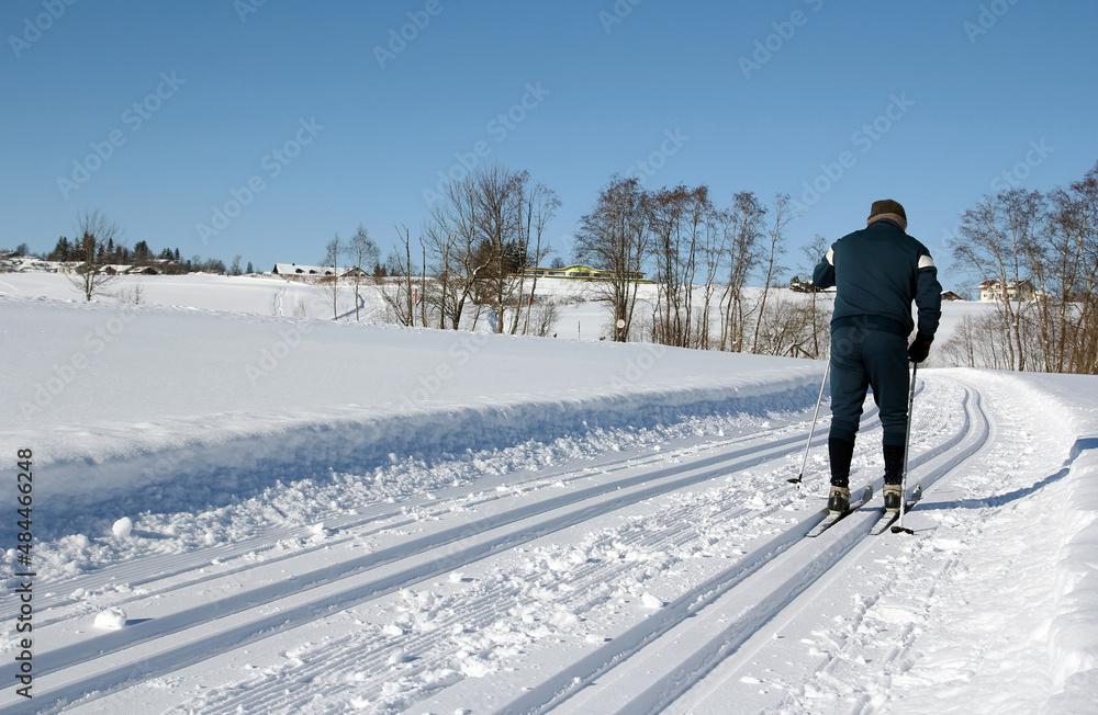 Ein Skilangläufer auf einer Langlaufloipe im Winter in Bayern