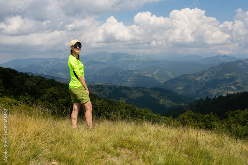 Hipster girl standing on rock cliff breathtaking view using smartphone with good connection keep in touch on solo hiking,woman wanderlust explore wild nature with mobile network coverage in mountains