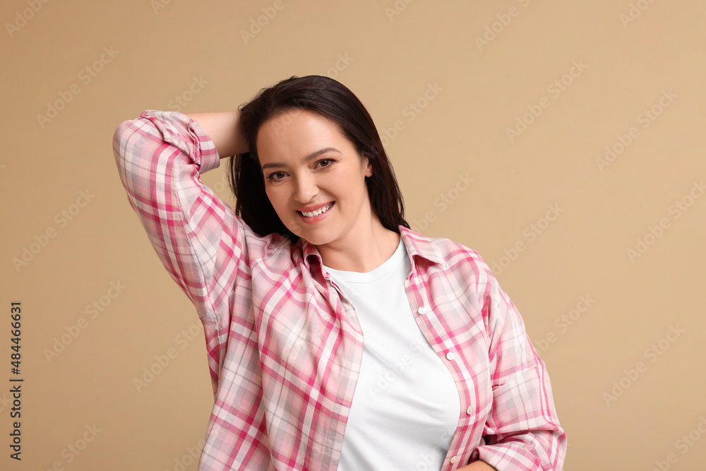 Beautiful overweight woman with charming smile on beige background Beautiful overweight woman with charming smile on beige background