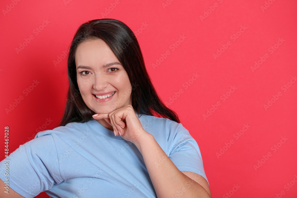 Beautiful overweight woman with charming smile on red background. Space for text Beautiful overweight woman with charming smile on red background. Space for text