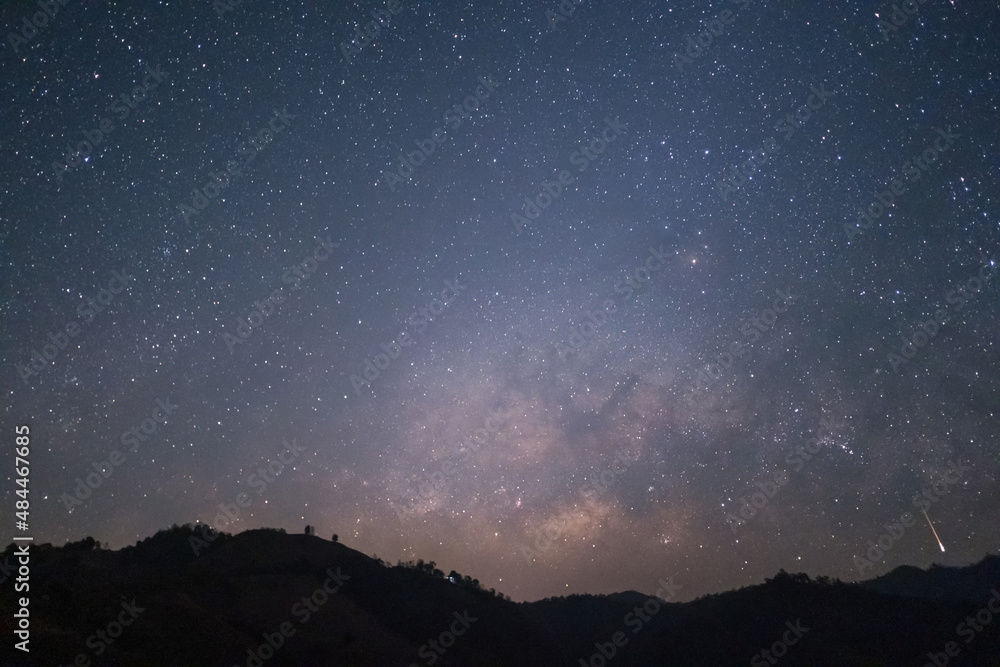 The Milky Way rising in the sky with meteor above the silhouette mountains at Mae Hong Son province Northern Thailand.