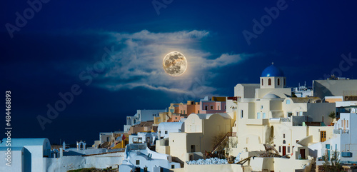 Tableau sur toile Moon in the night sky over Santorini Greece
