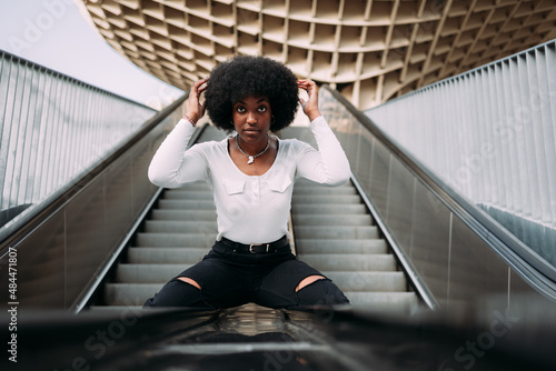 Portrait of a young black woman getting her hair done in the street photo