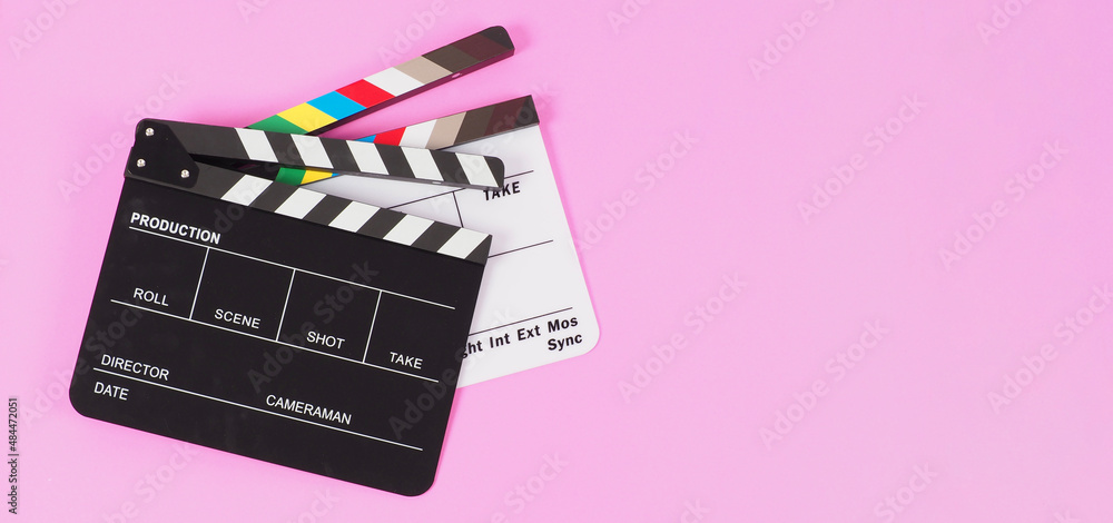 Two Black and white clapper board or movie slate on pink background. Full shot