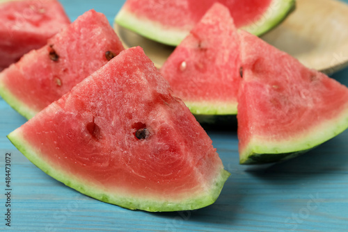 Slices of tasty ripe watermelon on turquoise wooden table, closeup