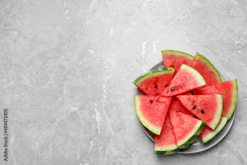 Slices of tasty ripe watermelon on light grey marble table, top view photo