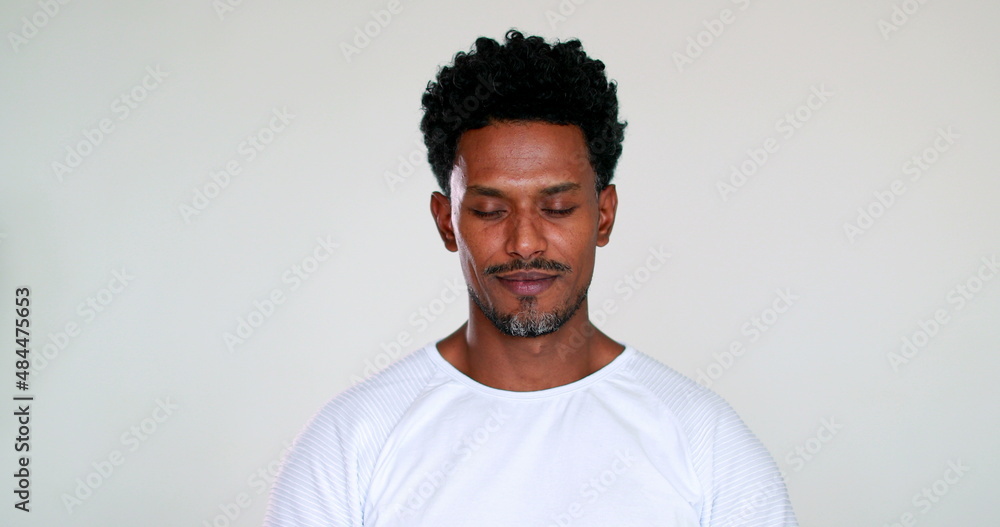 Pensive African man opening eyes smiling, expressing emotion Pensive African man opening eyes smiling, expressing emotion