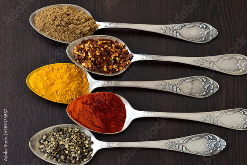 Spices on five spoons.