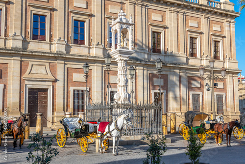 Horse drawn carriages line up for hire in the historic Plaza del Triunfo, in the Barrio Santa Cruz district of Seville, Spain.