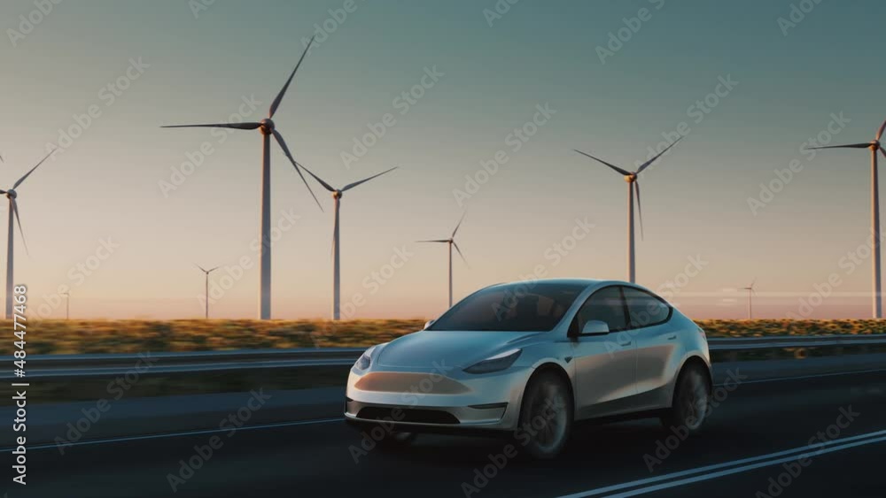 An electric car drives along the road against the backdrop of Wind power plants. Sunset. Clean renewable energy technologies. Green energy recovery concept